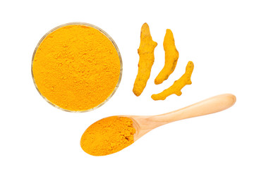 Turmeric powder in glass bowl, dry roots and wooden spoon isolated on white background.
