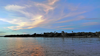 Zambezi River. The rays of the setting sun painted clouds on a blue sky in fantastic pink, gold,...