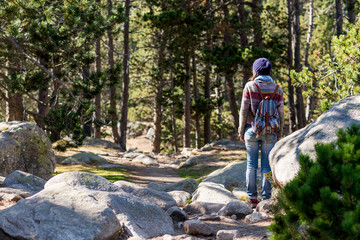 Rear view of a backpacker woman wearing a wool cap hiking