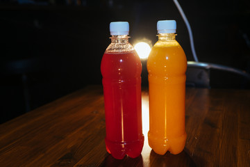 plastic bottles with soft drinks, mors and orange juice. red and yellow © kapralov