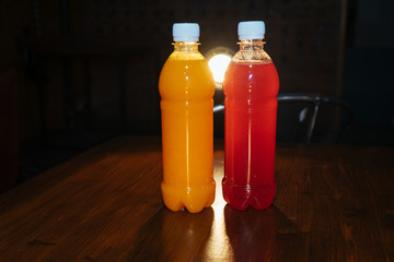 plastic bottles with soft drinks, mors and orange juice. red and yellow © kapralov
