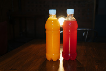 plastic bottles with soft drinks, mors and orange juice. red and yellow © kapralov