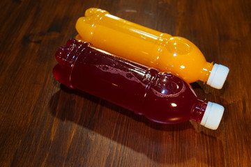 plastic bottles with soft drinks, mors and orange juice. red and yellow © kapralov