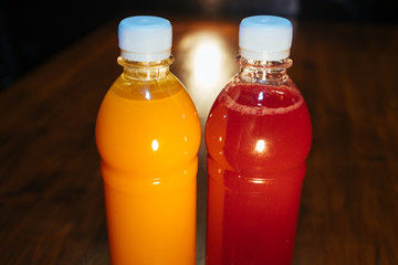 plastic bottles with soft drinks, mors and orange juice. red and yellow © kapralov