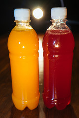 plastic bottles with soft drinks, mors and orange juice. red and yellow © kapralov
