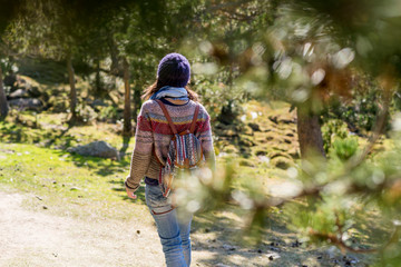 Rear view of a backpacker woman wearing a wool cap hiking