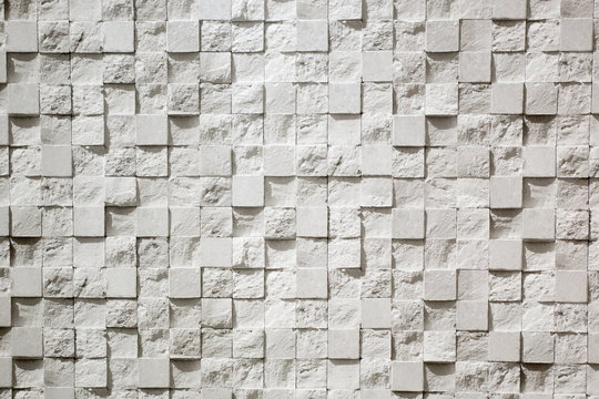Wall plastered in the form of repeating squares mosaic, 3D texture. The gray background of decorative stucco squares. Textured Wallpaper.