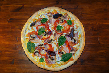 vegetarian Italian pizza with herbs and mushrooms and Basil on a wooden table
