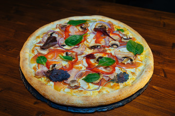 vegetarian Italian pizza with herbs and mushrooms and Basil on a wooden table