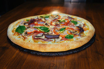 vegetarian Italian pizza with herbs and mushrooms and Basil on a wooden table