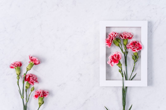Mother's Day, Valentine's Day background design concept, beautiful pink, red carnation flower bouquet on marble table, top view, flat lay, copy space.
