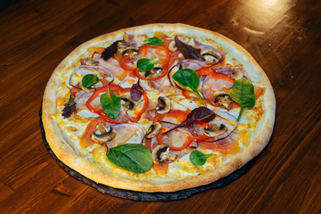 vegetarian Italian pizza with herbs and mushrooms and Basil on a wooden table