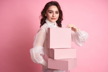  Young girl holding a pink box on a pink background