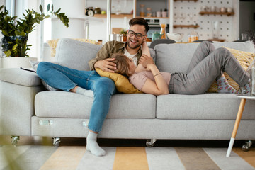 Young loving couple in sofa. Happy couple relaxing in living room.