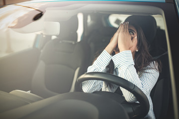 Cropped shot of a young woman looking stressed-out while sitting in her car. Stressed woman driver. Transportation concept. Sad businesswoman driver sitting in car