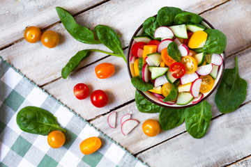 Concept of healthy food, clean eating, dieting. Colorful fresh vegetable salad in a bowl. Easy to cook, perfect summer light meal. Wooden background flat lay top view