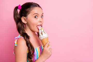 Closeup profile photo of beautiful little lady two cute long tails hold big cone ice cream delicious lick tongue try vanilla taste wear summer dress isolated pastel pink color background - obrazy, fototapety, plakaty