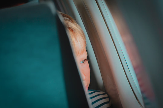 Little Boy Travel By Plane Looking Through Window