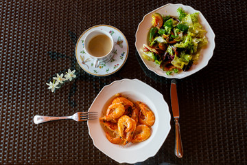 delicious lunch of fried shrimp with garlic, green salad , a cup of coffee