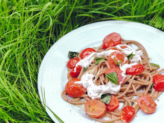 Italian pasta with creamy cheese, tomato and basil