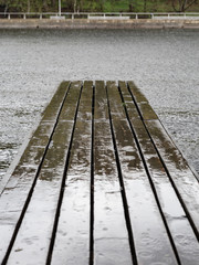 Wooden pier after rain and river water