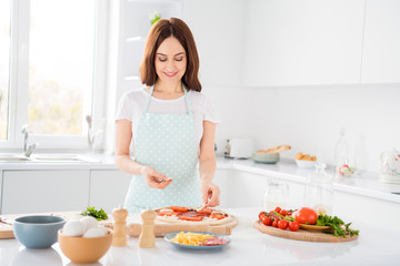Obraz na płótnie Canvas Photo of beautiful cheerful housewife quarantine hobby preparing family recipe mushroom slices on dough italian pizza stay home safety concept modern kitchen indoors