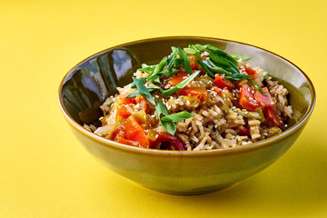 Bowl with Fried Rice and Vegetables. Traditional chinese food. horizontal view on yellow
