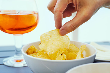 young man taking a potato chip from a bowl