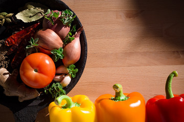 Arrangement of colorful veggies, herbs and spices on wooden board. Food/homemade cooking background.