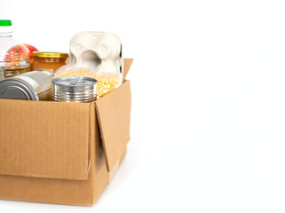 Coronavirus donation concept. Donation box with food isolated on white. Canned food, dried peas, rice, nuts. Top view. Copy space