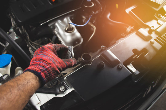 Mechanic man with red glove is opening radiator cap of a car,Automotive maintenance concept.