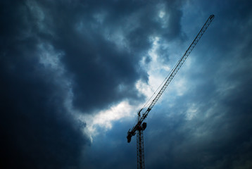 Construction crane under overcasted clouds