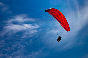 One paraglider is flying in the blue sky. Paragliding on a sunny day.