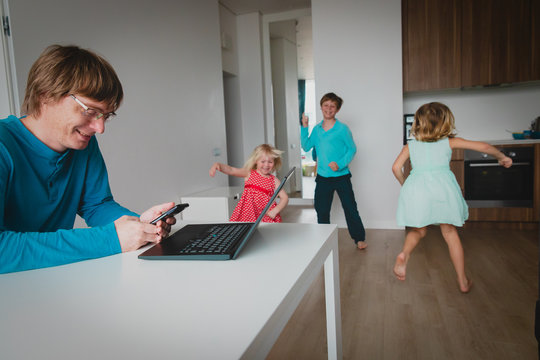 Family Stay Home, Father Working Remotely While Kids Dance And Have Fun