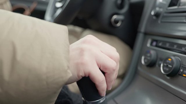 Womans hand in a manual gearbox. Close-up.