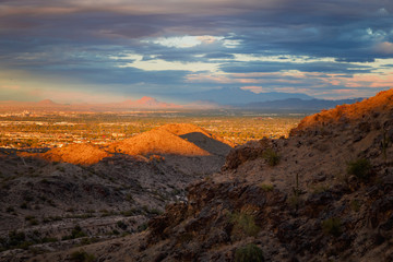A landscape with dramatic sun light on the mountains. A beautiful view of the valley, red mountain and four peaks at the backdrop can be seen from south mountain, Phoenix Arizona. Selective focus.