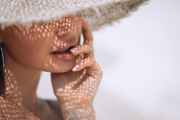 Portrait of a beautiful woman in a straw hat with french manicure. Cosmetics,makeup and beauty....