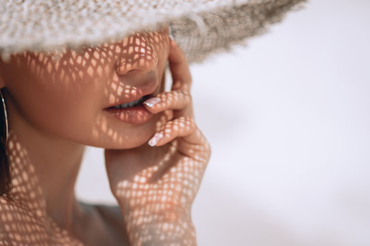 Portrait of a beautiful woman in a straw hat with french manicure. Cosmetics,makeup and beauty. Spa. Copy space