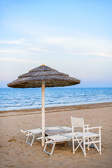 Sunbeds and umbrella on empty beach