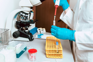Close-up photo of lab technician working with micropipette and samples.