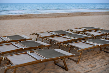 Sunbeds on empty sandy beach