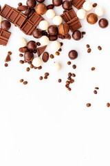 Chocolate background on white table top-down frame. Sweet desserts concept. Copy space