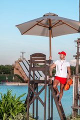 Young handsome Lifeguard climbs the stairs into the lifeguard tower