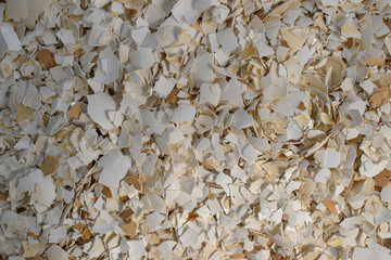Egg shell for backdrop. Small pieces with sharp edges. Brown and white color. Concept of processing Eggshell and calcium carbonate as a raw material in lime production.
