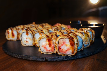 A set of sushi. Philadelphia roll, California, unagi, black dragon with fresh ingredients. The sushi menu. Japanese cuisine. Ginger and wasabi. Soy sauce. Sesame. Hot, baked, breaded