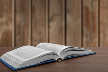 Open book on old wooden table.