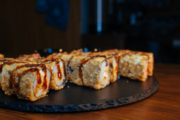 A set of sushi. Philadelphia roll, California, unagi, black dragon with fresh ingredients. The sushi menu. Japanese cuisine. Ginger and wasabi. Soy sauce. Sesame. Hot, baked, breaded