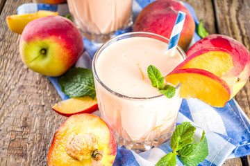 Summer breakfast drink, fresh blended peach smoothie, peach yogurt with nectarine fruit slices,...