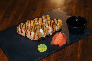 A set of sushi. Philadelphia roll, California, unagi, black dragon with fresh ingredients. The sushi menu. Japanese cuisine. Ginger and wasabi. Soy sauce. Sesame. Hot, baked, breaded