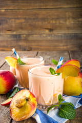 Summer breakfast drink, fresh blended peach smoothie, peach yogurt with nectarine fruit slices,...